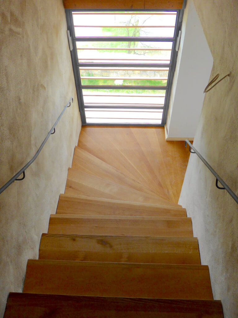 Treppenanlage zwischen beiden Gebäudeteilen aus - Betontreppe mit Eichenholzbelag